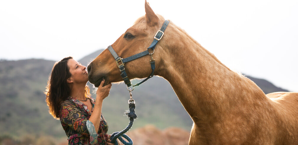 Andree holding horse's head up